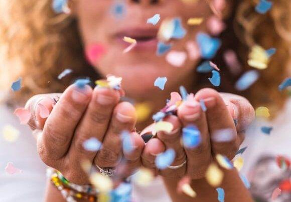 Be So Well - Wellness Celebration - woman blowing confetti