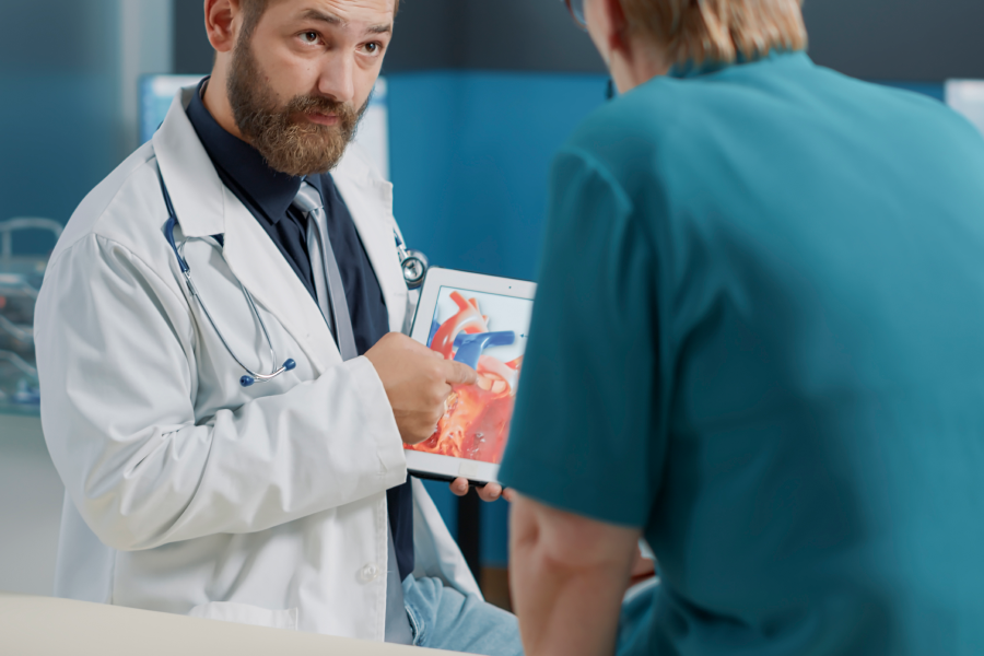 Doctor Holding a tablet explaining cholesterol to a patient